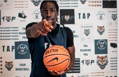 TAP athlete pointing at the camera in front of a TAP backdrop